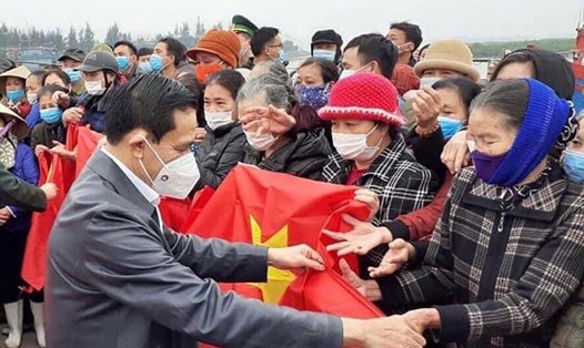 Chủ tịch UBND tỉnh Hà Tĩnh Võ Trọng Hài tặng cờ cho ngư dân. Ảnh: CĐ