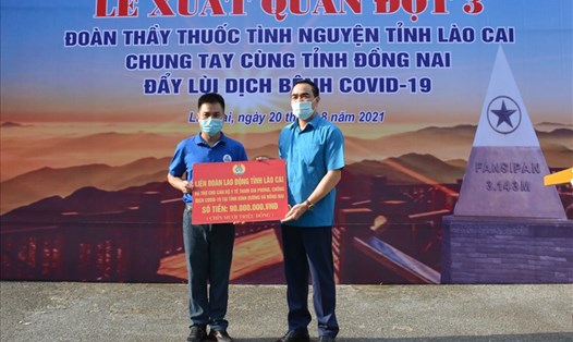 Lãnh đạo LĐLĐ tỉnh Lào Cai (bên phải) trao hỗ trợ cho lực lượng tuyến đầu chống dịch. Ảnh: CĐCC