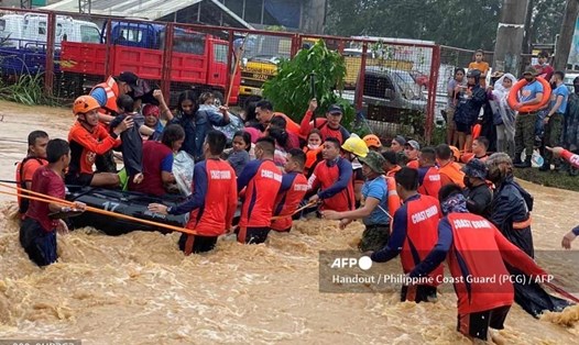 Lực lượng cứu hộ sơ tán người dân khỏi những ngôi nhà bị ngập lụt khi siêu bão Rai đổ bộ vào Philippines. Ảnh: AFP