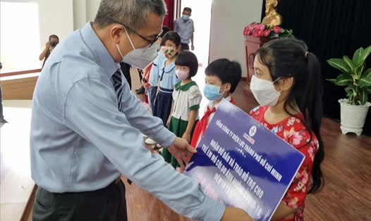 Ông Nguyễn Văn Thanh - Tổng Giám đốc EVNHCMC - trao hỗ trợ học bổng cho trẻ em mồ côi vì COVID-19. Ảnh: Nam Dương
