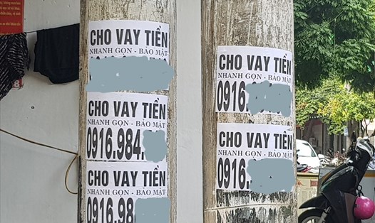Tờ rơi quảng cáo cho vay tiền được dán chi chít tại các cột điện dọc 2 bên đường Hải Thượng Lãn Ông (Thành phố Ninh Bình). Ảnh: NT