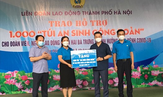 Bà Nguyễn Thị Kim Dung - Chủ tịch Liên đoàn Lao động quận Hai Bà Trưng (thứ 2 từ trái sang) - nhận hỗ trợ cho đoàn viên, người lao động ảnh hưởng COVID-19. Ảnh: Kiều Vũ
