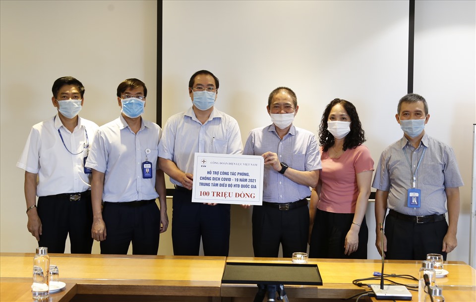 Lãnh đạo Công đoàn Điện lực Việt Nam (bên trái) trao hỗ trợ cho đại diện đoàn viên khó khăn do COVID-19. Ảnh: CĐCC