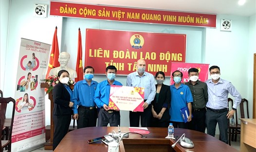 MOVI trao tặng biển tượng trưng 100 phần quà nhu yếu phẩm cho Liên đoàn Lao động tỉnh Tây Ninh. Ảnh Minh Triệu