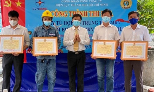 Ông Lê văn Minh - Chủ tịch Công đoàn EVNHCMC (giữa) - trao khen thưởng cho các tập thể, cá nhân có nhiều sáng kiến, cải tiến kỹ thuật trong quá trình thực hiện công trình. Ảnh: Đức Long