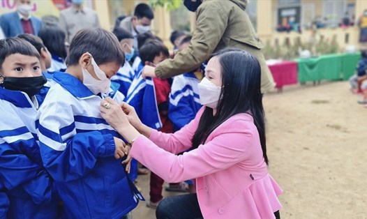 Cô Thủy, giáo viên tiểu học tại TP Vinh trao tặng áo ấm cho học sinh miền núi. Ảnh: Hải Đăng
