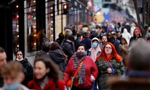 Người dân đi lại trên đường phố Oxford ở thủ đô London, Anh, chỉ một số người đeo khẩu trang phòng COVID-19. Ảnh: AFP