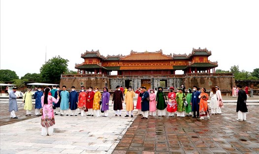 Du khách mặc áo dài chụp ảnh lưu niệm ở Hoàng thành Huế. Ảnh: PĐ.