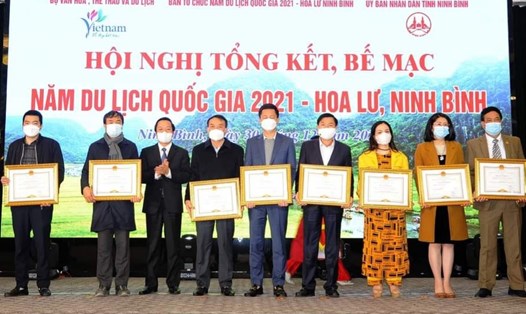 Ông Phạm Quang Ngọc, Chủ tịch UBND tỉnh Ninh Bình - Trưởng ban Tổ chức Năm Du lịch Quốc gia 2021 trao bằng khen cho các cá nhân, tập thể có thành tích xuất sắc trong tổ chức các hoạt động Năm Du lịch Quốc gia 2021. Ảnh: NT