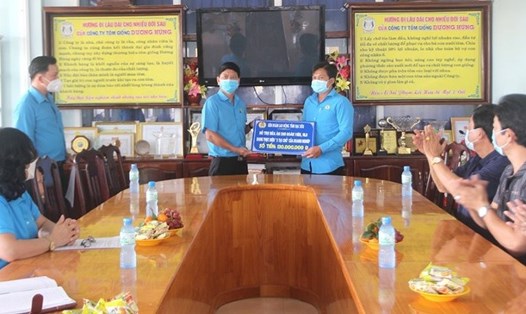 Ông Huỳnh Nguyễn Trúc Linh, Phó Chủ tịch Thường trực LĐLĐ tỉnh (bên trái) trao bảng tượng trưng hỗ trợ Công nhân Công ty Tôm giống Dương Hùng (huyện Đông Hải).Ảnh: Nguyễn Quốc