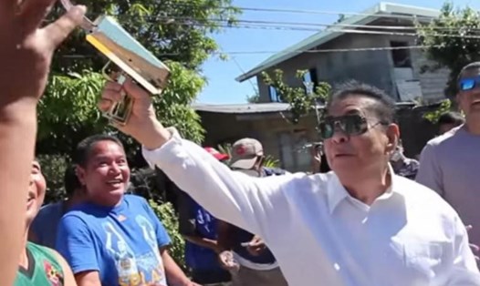 Thị trưởng Philipines dùng súng bắn mưa tiền cho người dân gây xôn xao. Ảnh chụp màn hình