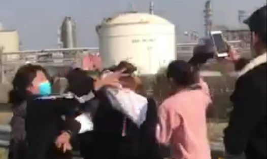 Nam sinh thản nhiên quay clip nhóm nữ sinh đánh hội đồng 2 thiếu nữ. Phía sau là nhà máy lọc dầu Nghi Sơn. Ảnh cắt từ clip