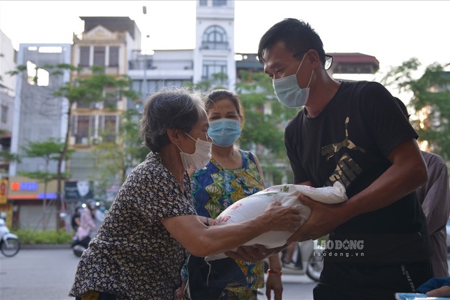Phát gạo, khẩu trang miễn phí cho người khó khăn vì dịch COVID-19 tại Hà Nội. Ảnh: Tùng Giang