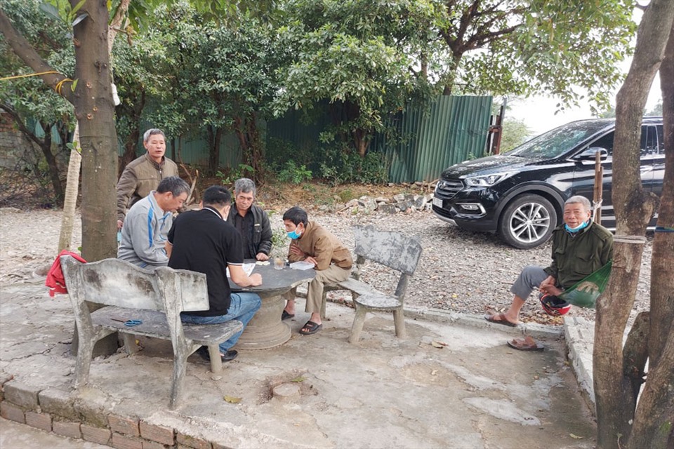 Ông Chính ngoài cùng bên phải cùng các bạn đồng niên tụ tập bàn tán xôn xao về chuyện sốt đất trên địa bàn. Ảnh: Trần Tuấn.