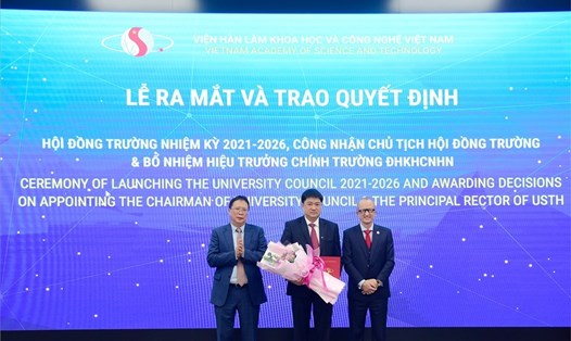 GS.VS Châu Văn Minh (ngoài cùng, bên trái) trao quyết định công nhận Chủ tịch Hội đồng trường cho GS. Chu Hoàng Hà (giữa).