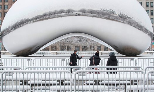 Một người đàn ông chụp ảnh với tuyết ở Chicago, Illinois. Dự báo thời tiết cho biết, khu vực này có nguy cơ hứng trận bão tuyết lớn nhất trong vòng 2 năm qua. Ảnh: AFP.
