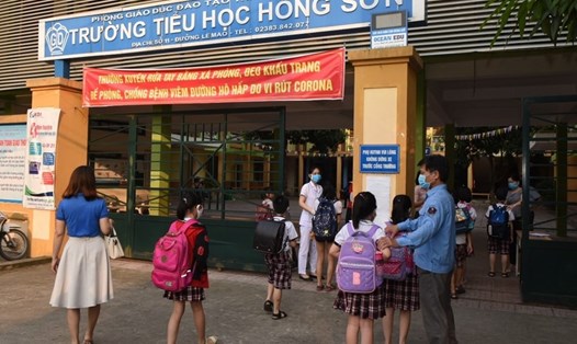 Học sinh trường Tiểu học Hồng Sơn (TP. Vinh) được hướng dẫn bảo đảm khoảng cách phòng chống COVID-19. Ảnh: Quang Đại
