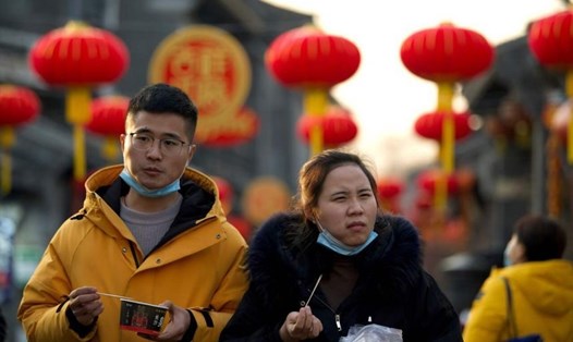 Một cặp đôi tản bộ trên đường phố Bắc Kinh đã trang hoàng trước Tết Nguyên đán. Ảnh: AFP.
