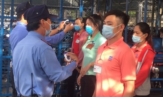 Công nhân Công ty May mặc Triple Việt Nam được đo thân nhiệt trước khi vào làm việc để phòng chống dịch COVID-19. Ảnh: Đức Long