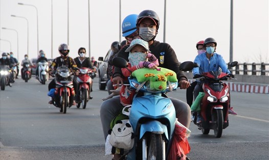 Những đứa trẻ trên xe máy cùng cha mẹ vượt hàng trăm km trở lại Bình Dương. Ảnh: Đình Trọng