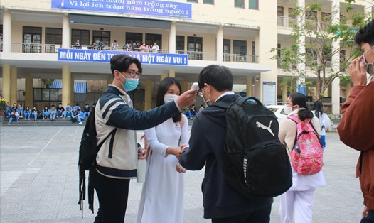 Trở lại trường sau Tết, học sinh Đà Nẵng xếp hàng đo thân nhiệt. Ảnh: TT