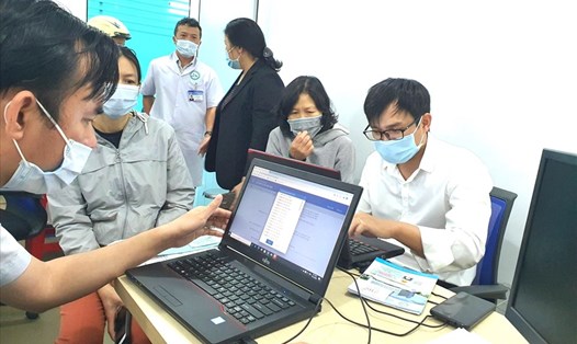 Cán bộ ngành BHXH Việt Nam hướng dẫn người dân cài đặt ứng dụng “VssID - Bảo hiểm xã hội số”. Ảnh: BHXH