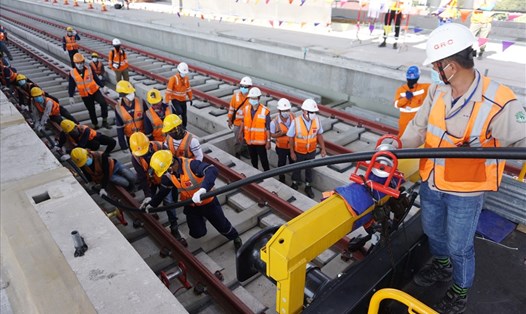 Công nhân kéo cáp thi công hệ thống điện ở đoạn từ ga Thủ Đức tới depot Long Bình tuyến metro số 1. Ảnh: Minh Quân