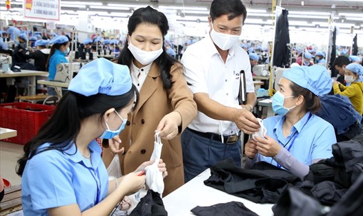 Lãnh đạo một công ty may mặc ở Quảng Trị tặng khẩu trang cho công nhân và nhắc nhở việc phòng dịch COVID-19. Ảnh: Hưng Thơ