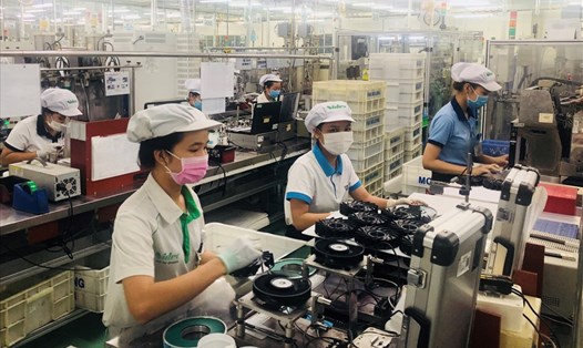 Công nhân Cty Nidec Việt Nam (TPHCM) phải đeo khẩu trang khi làm việc để phòng chống lây lan dịch bệnh COVID-19. 
Ảnh: Nam Dương