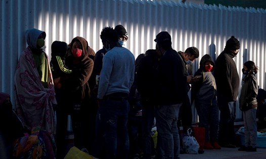 Nhóm người nhập cư chờ bên ngoài điểm kiểm soát biên giới El Chaparral trong nỗ lực đi đến Mỹ từ Tijuana, bang Baja California, Mexico, hôm 19.2. Ảnh: AFP.