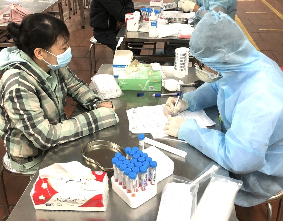 Cán bộ y tế lấy mẫu xét nghiệm virus SARS-CoV-2 đối với người lao động quay trở lại Hưng Yên sau kỳ nghỉ Tết Nguyên đán. Ảnh: Phương Hà