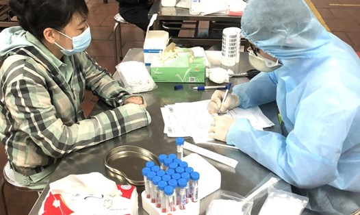 Cán bộ y tế lấy mẫu xét nghiệm virus SARS-CoV-2 đối với người lao động quay trở lại Hưng Yên sau kỳ nghỉ Tết Nguyên đán. Ảnh: Phương Hà