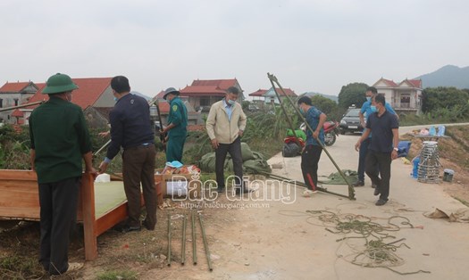 Lực lượng chức năng dỡ bỏ chốt phòng dịch cách ly y tế tại thôn Kiệu Đông, xã Cẩm Lý (Lục Nam). Ảnh: Báo Bắc Giang.
