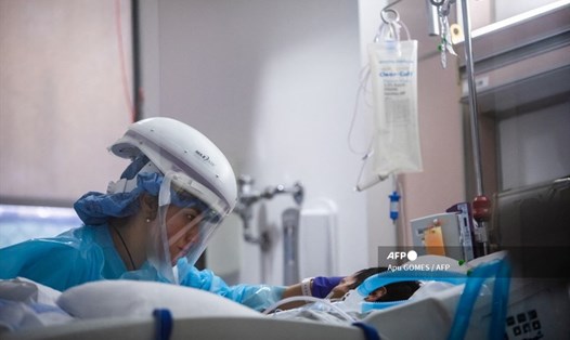Một y tá mặc đồ bảo hộ khi chăm sóc bệnh nhân COVID-19 tại Tarzana, California. Ảnh: AFP.