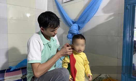 Anh Nguyễn Việt Đông - công nhân KCN Thăng Long (Hà Nội) - chăm sóc con. Ảnh: Khánh An