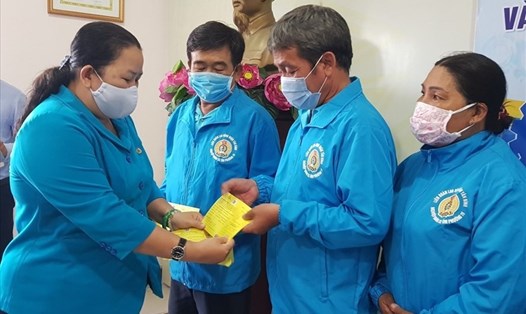 Bà Lê Thị Kim Thúy - Phó Chủ tịch LĐLĐ TPHCM - trao thẻ Bảo hiểm tai nạn cho các đoàn viên Nghiệp đoàn xe ôm Quận Tân Bình. Ảnh: Đức Long