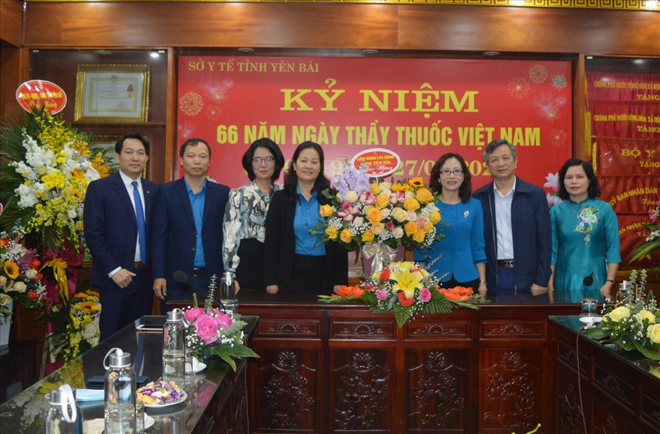 Đồng chí Ngô Hồng Hạnh, Phó Chủ tịch Thường trực LĐLĐ tỉnh Yên Bái (thứ 4 từ trái sang) tặng hoa và quà chúc mừng Ban Giám đốc Sở Y tế tỉnh Yên Bái. Ảnh: Thu Hiền