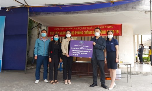 Đại diện Ford Việt Nam (thứ 2 từ phải sang) trao hỗ trợ cho đại diện Bệnh viện Đại học kỹ thuật y tế tỉnh Hải Dương. Ảnh: Nhi Nguyễn