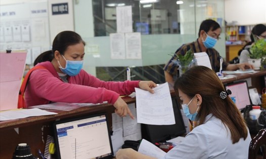 Cán bộ ngành BHXH Việt Nam hướng dẫn người dân hoàn thiện hồ sơ BHXH. 
Ảnh: Hà Anh
