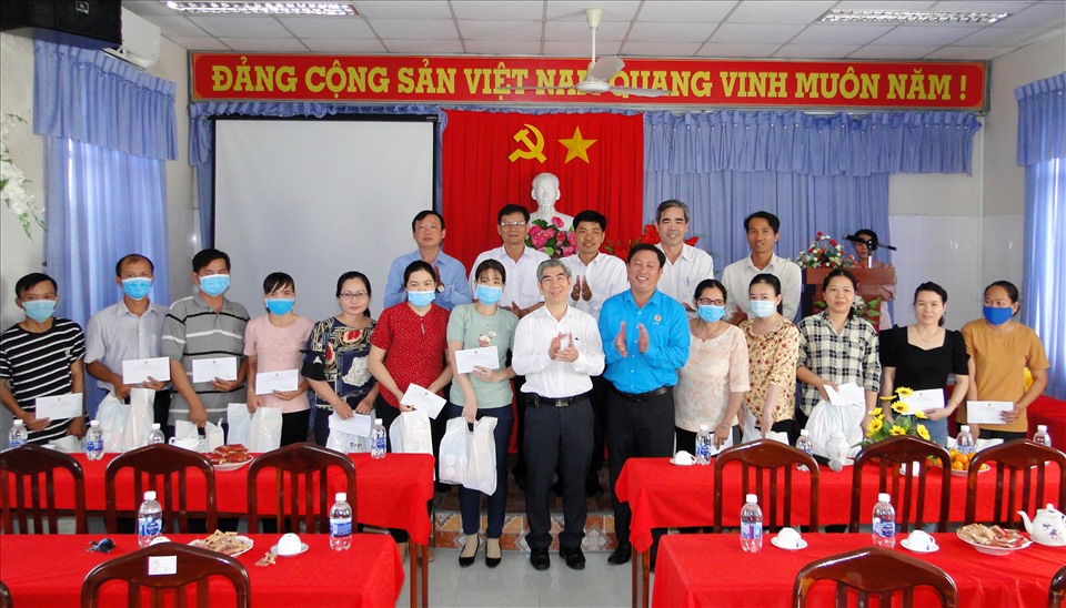 Ông Trần Thanh Thảo (áp trắng) và ông Nguyễn Trung Tần (áo xanh) trao quà Tết cho các công đoàn viên. Ảnh: k.Q