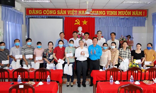 Ông Trần Thanh Thảo (áp trắng) và ông Nguyễn Trung Tần (áo xanh) trao quà Tết cho các công đoàn viên. Ảnh: k.Q