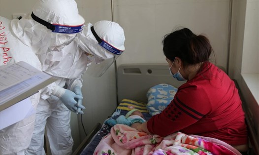 Bác sĩ BV Bạch Mai thăm khám cho bé 27 ngày tuổi mắc COVID-19. Ảnh: Bộ Y tế cung cấp