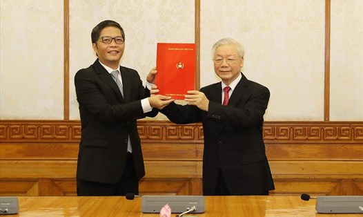 Tổng Bí thư, Chủ tịch Nước Nguyễn Phú Trọng trao quyết định và tặng hoa chúc mừng đồng chí Trần Tuấn Anh.