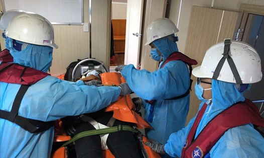 Lực lượng chức năng chuyển thuyền viên người Philippines bị nạn từ tàu SAR27-01 lên bờ đi cấp cứu. Ảnh: Phương Linh