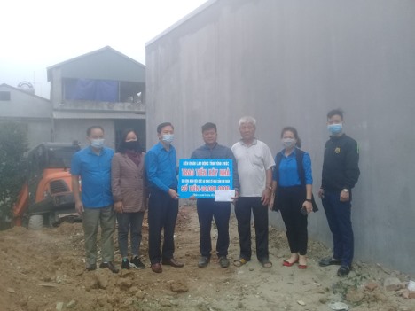 Lãnh đạo LĐLĐ tỉnh Vĩnh Phúc trao tiền hỗ trợ xây nhà cho anh Nguyễn Đình Tuyển. Ảnh: Quốc Hương