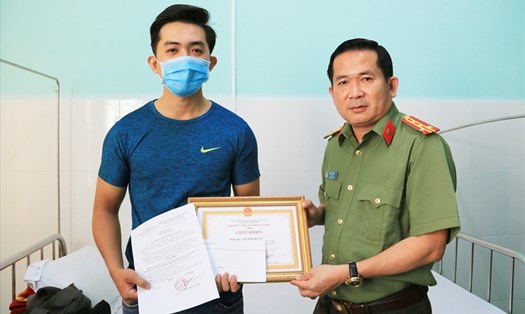 Đại tá Đinh Văn Nơi trao Giấy khen cho Công an viên Lâm Thanh Tân. Ảnh: Nghiêm Túc