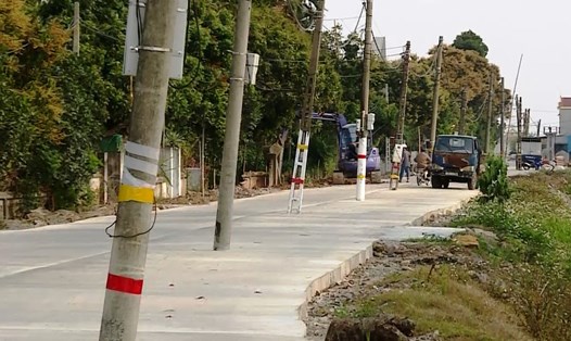 Tuyến đường qua xã Khánh Thủy, huyện Yên Khánh sau khi được đầu tư mở rộng hơn 40 cột điện này vẫn chưa được di dời, tiềm ẩn nhiều nguy cơ tai nạn giao thông. Ảnh: NT