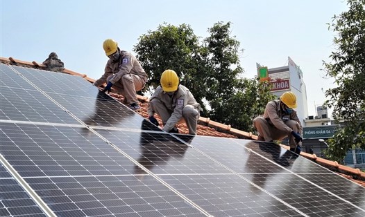 Các thanh niên công nhân ngành điện lực TPHCM lắp đặt hệ thống điện mặt trời trên mái nhà Làng thiếu niên Thủ Đức. Ảnh Nam Dương