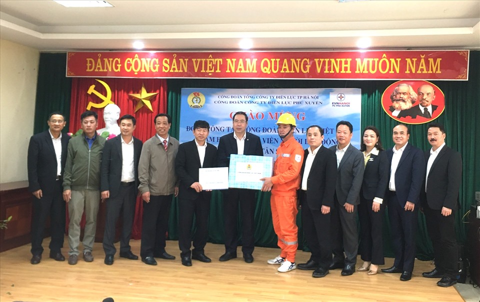 Ông Đỗ Đức Hùng - Chủ tịch Công đoàn Điện lực Việt Nam (thứ 6, từ trái sang) tặng quà nhân viên điện lực Hà Nội. Ảnh: Vân Anh