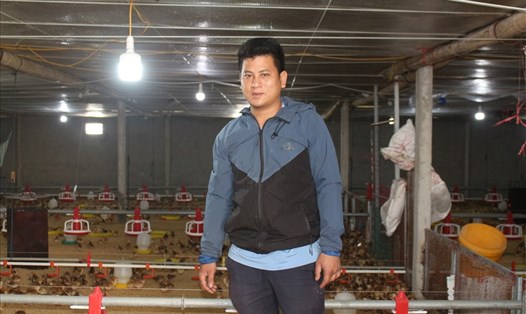 Anh Nguyễn Xuân Anh cùng mô hình trang trại gà sạch tự động trên địa bàn. Ảnh: Đình Linh